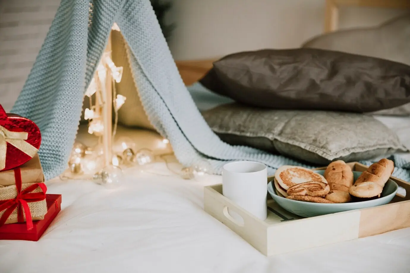 Frühstück und Geschenke in der Nähe eines Zelts aus Decken.